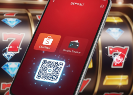 Mobile phone displaying an online casino ShopeePay deposit interface with DuitNow QR and e-wallet balance options, set against a blurred background of spinning slot machine reels.